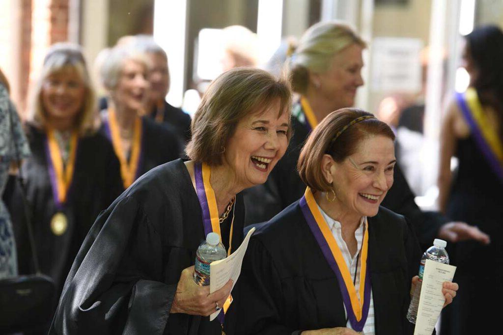 Members of the Golden Club laugh while wearing their medallions at reunion.